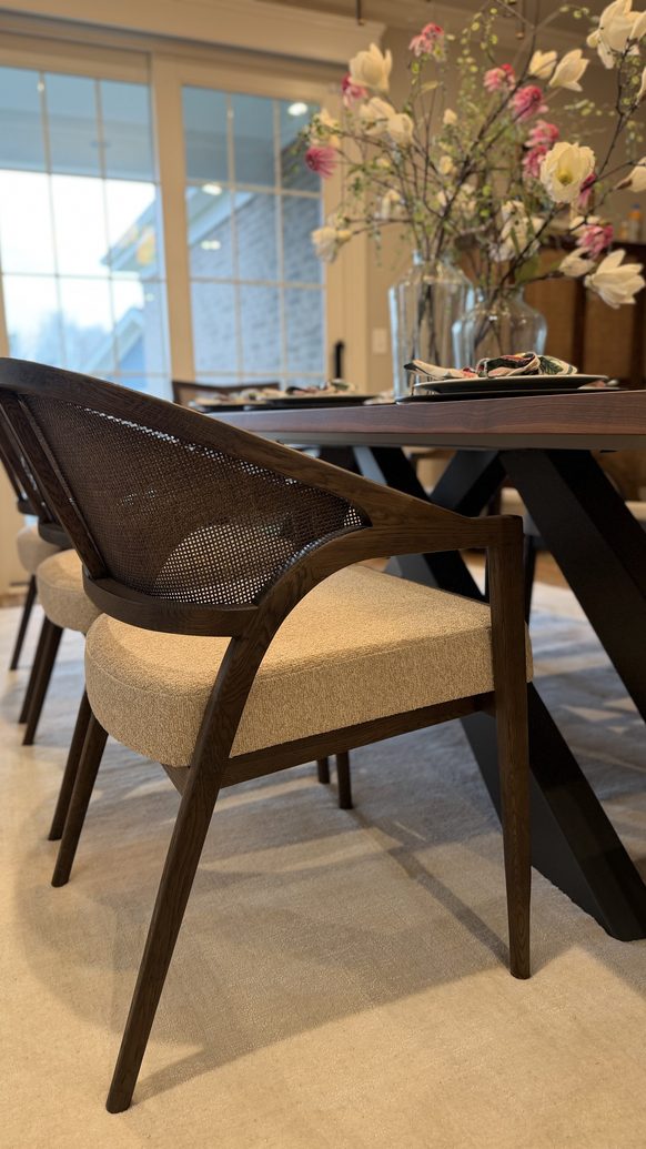 Detail of a sculptural dining chair against a live edge walnut table