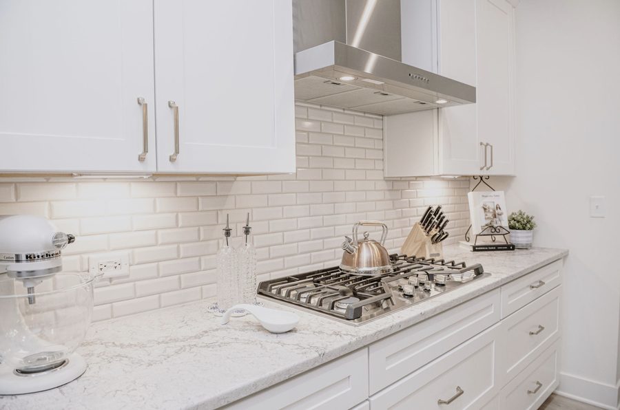Kitchen detail with a marble countertop, gas cooktop and white subway tile
