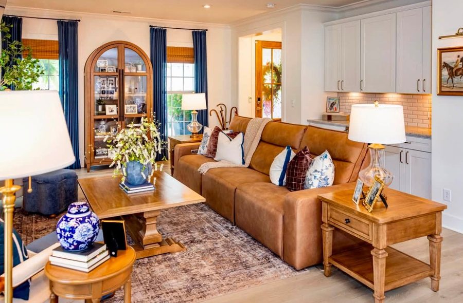 Living room with a caramel leather sofa, blue and white porcelain and warm wood tables