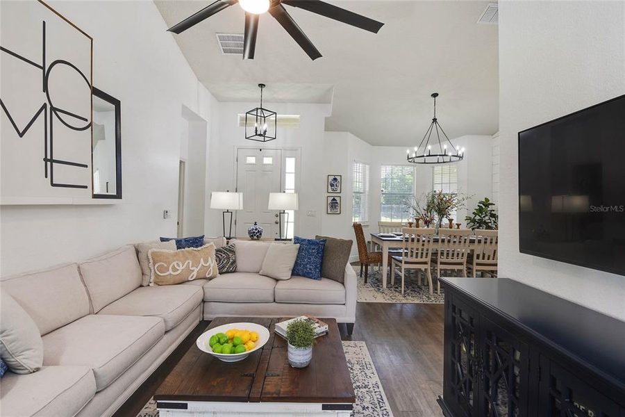 Living room open to the dining area with a sectional and layered neutral textiles