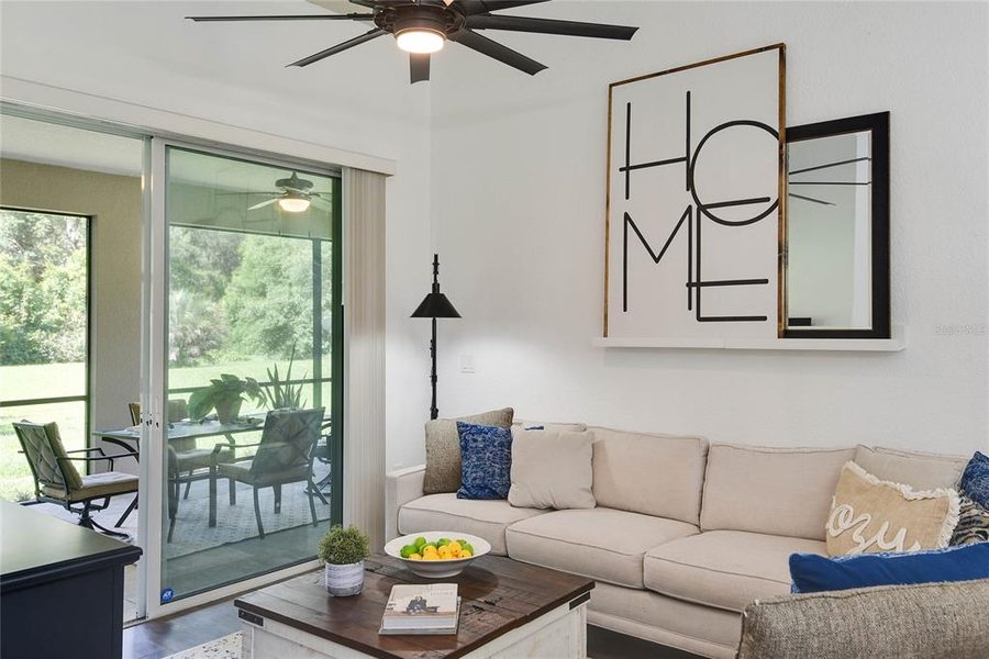 Living room with a sectional and sliding doors opening to a covered porch