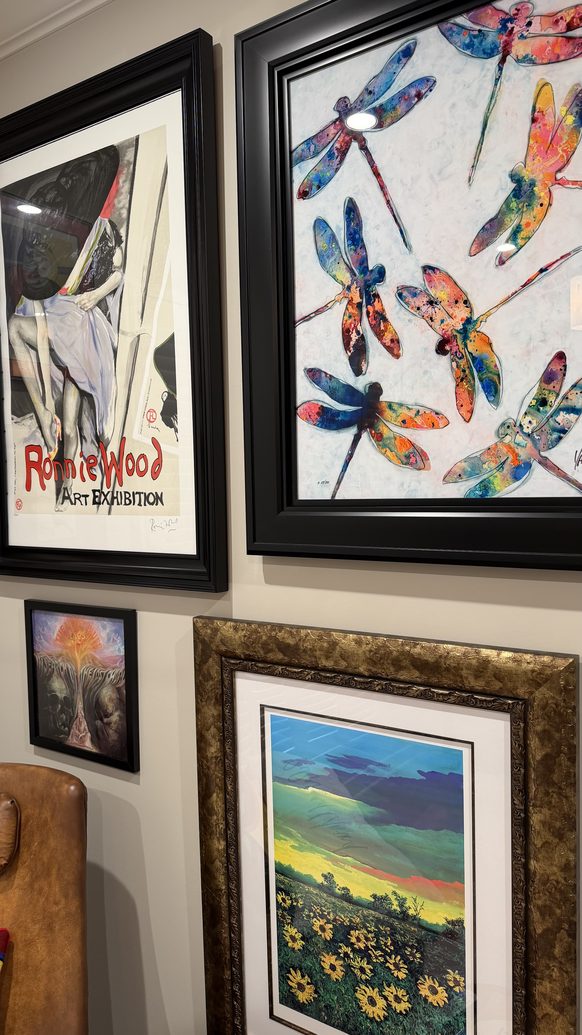 Framed art detail with a Ronnie Wood exhibition print and a dragonfly watercolour