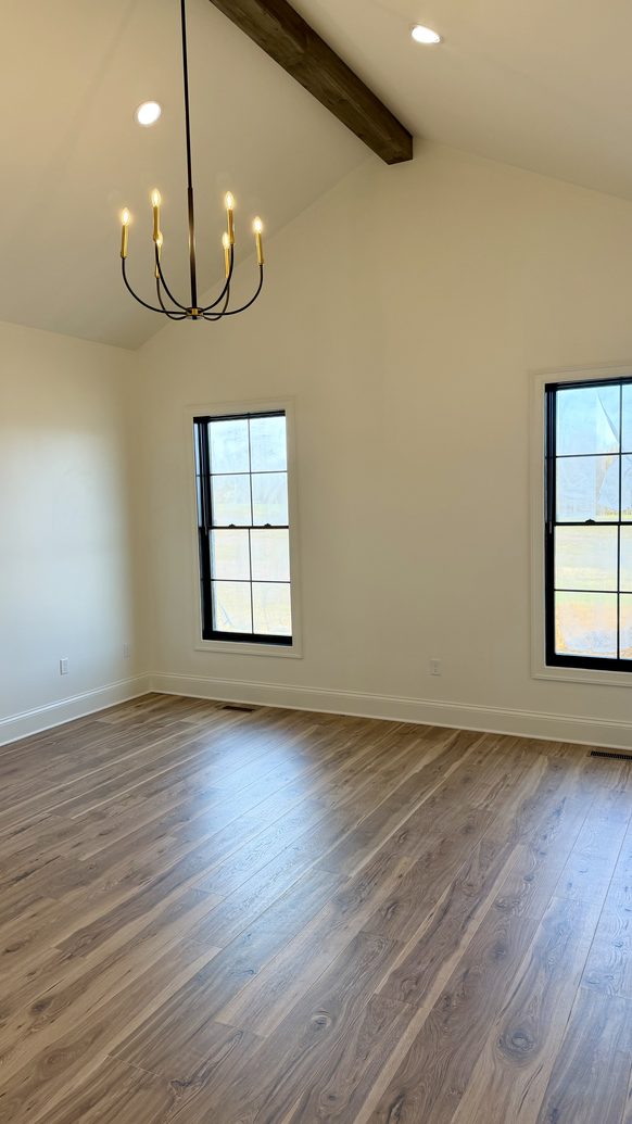 New construction living space with exposed beams and steel framed windows