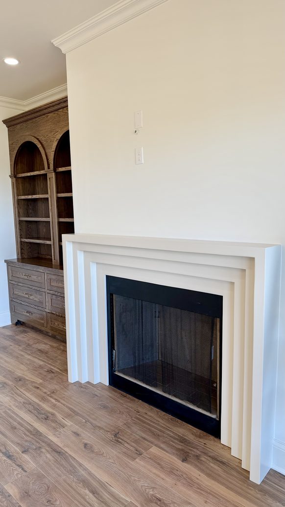 New construction fireplace surround with flanking arched built-in shelving