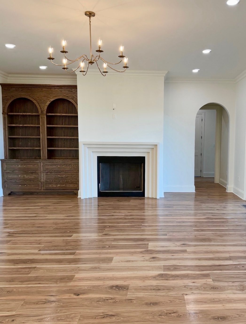 New construction great room with arched built-ins flanking the fireplace