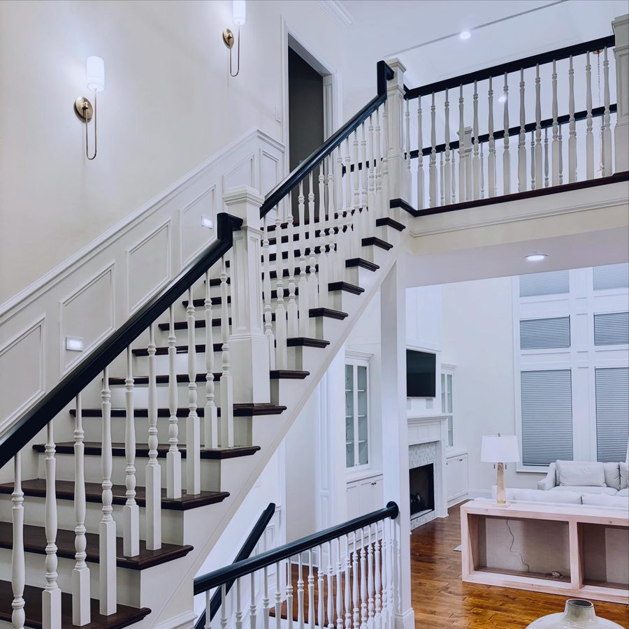 Two storey entry with a painted staircase, iron balusters and panelled walls