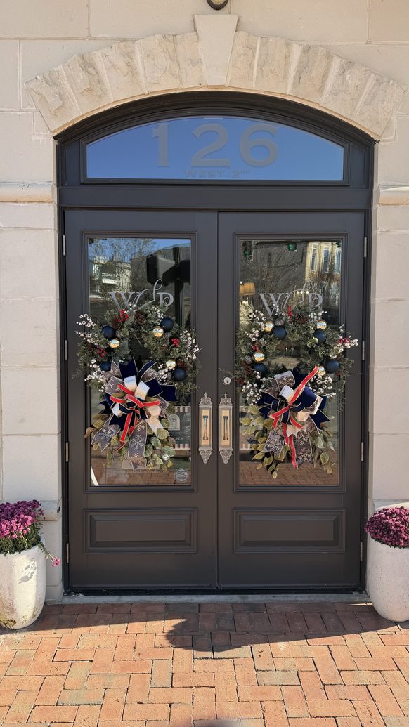 Arched double entry doors dressed with seasonal wreaths