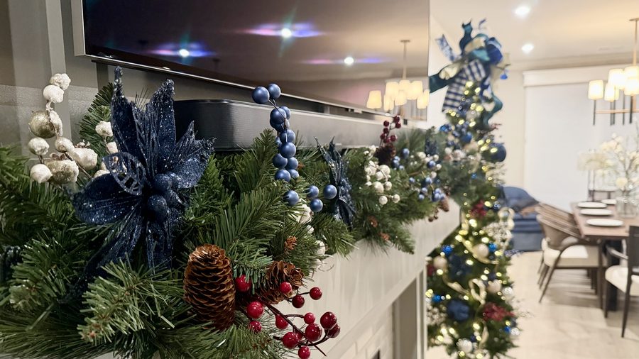 Christmas mantel garland in navy, silver and white with a decorated tree beyond