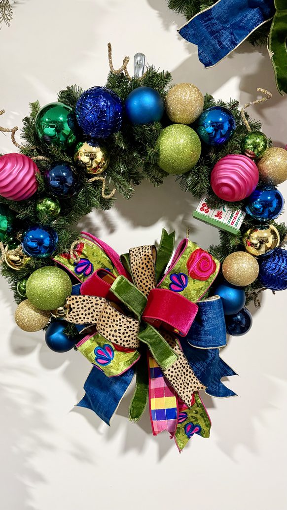 Christmas wreath in jewel tones with bright ornaments and ribbon