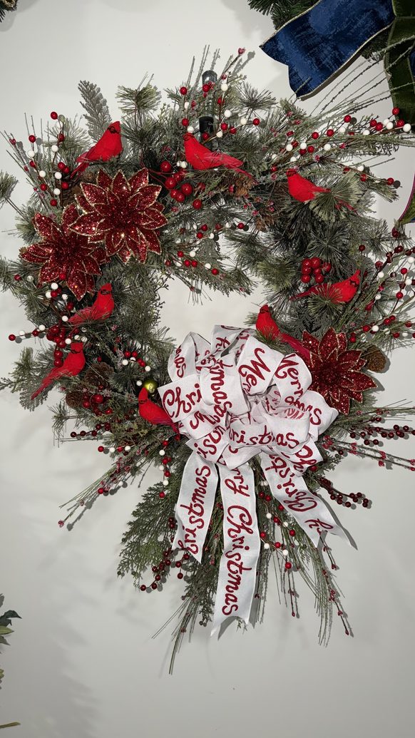 Christmas wreath with cardinals, red berries and frosted greenery