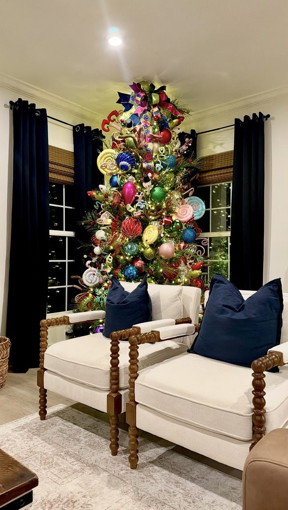 Fully decorated Christmas tree flanked by a pair of spool chairs